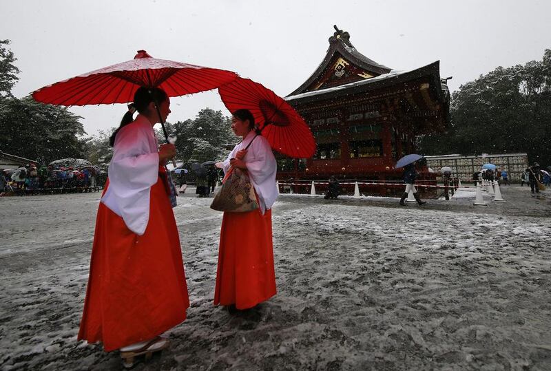 Shrine maidens chat in the snow at the Tsurugaoka Hachimangu Shrine in Kamakura, near Tokyo. Shizuo Kambayashi / AP Photo