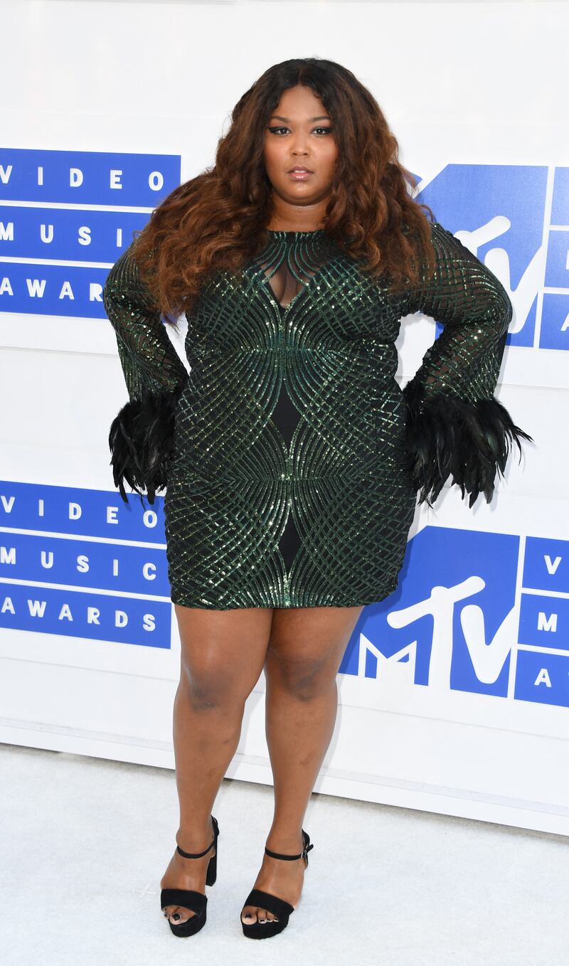 Lizzo wears a green and black mini dress with feathered cuffs at the 2016 MTV Video Music Awards on August 28, 2016, at Madison Square Garden, New York City. AFP