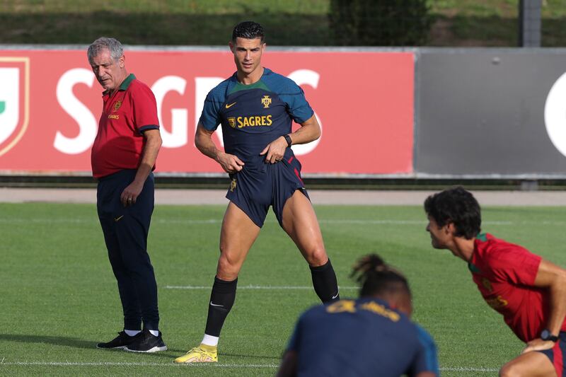 Portugal's head coach Fernando Santos, left, watches on as Cristiano Ronaldo and teammates warm-up. EPA