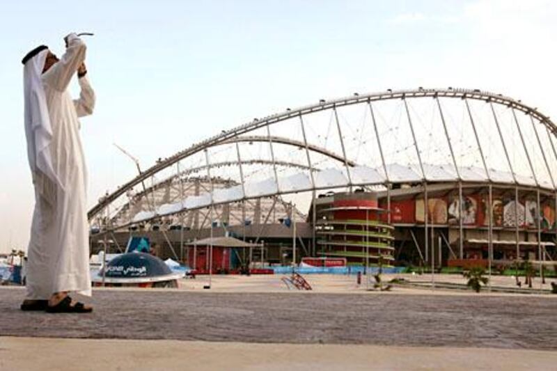 A man takes a picture outside the Khalifa Stadium a day before the start of the 15th Asian Games in Doha November 30, 2006.   REUTERS/Jason Reed   (QATAR)