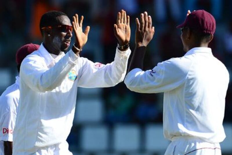 West Indies bowler Shane Shillingford (L) celebrates after taking the wicket of Australian batsman Michael Hussey, caught by Darren Sammy, during the first day of the third test match between the West Indies and Australia in Roseau, Dominica, April 23, 2012. Australia is leading the the three-test series 1-0.  AFP PHOTO/Emmanuel Dunand

