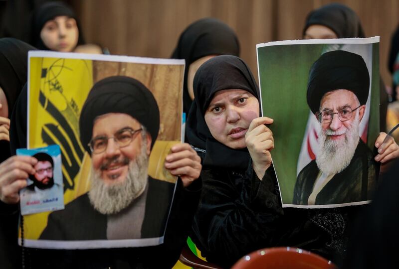 Supporters of Hezbollah hold photos of Hassan Nasrallah and Iran's supreme leader Ali Khamenei in southern Beirut.  EPA