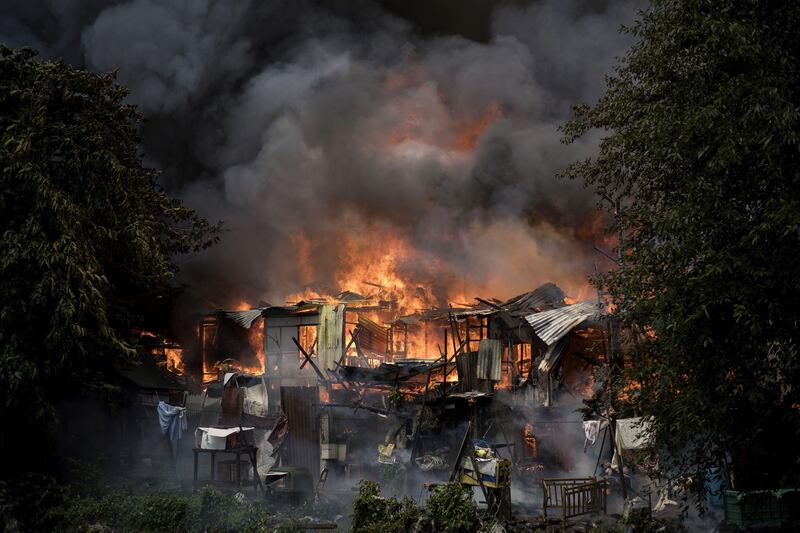 A fire engulfs an informal settlers area beside a river in Manila on August 11, 2017.
Fires are common hazards in the sprawling capital, where millions live in hovels made of scrap wood and cardboard and fire safety regulations are rarely imposed. / AFP PHOTO / NOEL CELIS