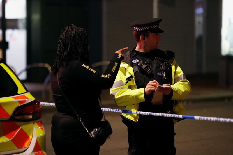 A person speaks to a police officer at a cordon after reported multiple stabbings in Reading. REUTERS