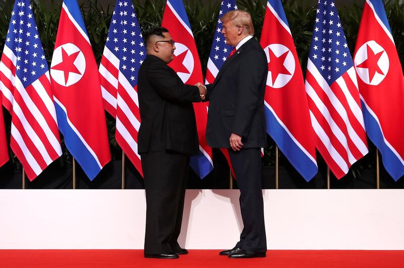 U.S. President Donald Trump and North Korea's leader Kim Jong Un shake hands during a summit at the Capella Hotel on the resort island of Sentosa, Singapore June 12, 2018.  REUTERS/Jonathan Ernst