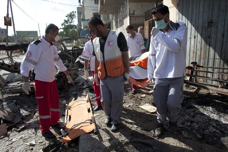 Palestinian medics at the scene where an ambulance driver and medic were killed by the Israeli army yesterday as they entered today to  the northern district of Beit Hanoun.