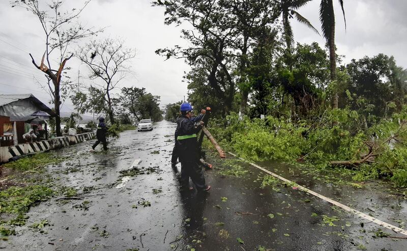 Workers clear a road of trees and branches in Sorsogon province, eastern Philippines. AP