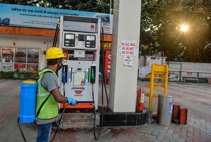A worker sprays disinfectant on a gas station during a government-imposed nationwide lockdown as a preventive measure against the Covid-19 coronavirus, in Siliguri.  AFP