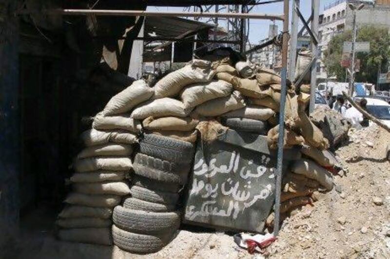 A sign at a checkpoint in Douma city near Damascus reads: "The beard of Arour is a brush for a soldier's boots", a reference to Sheikh Adnan Arour.