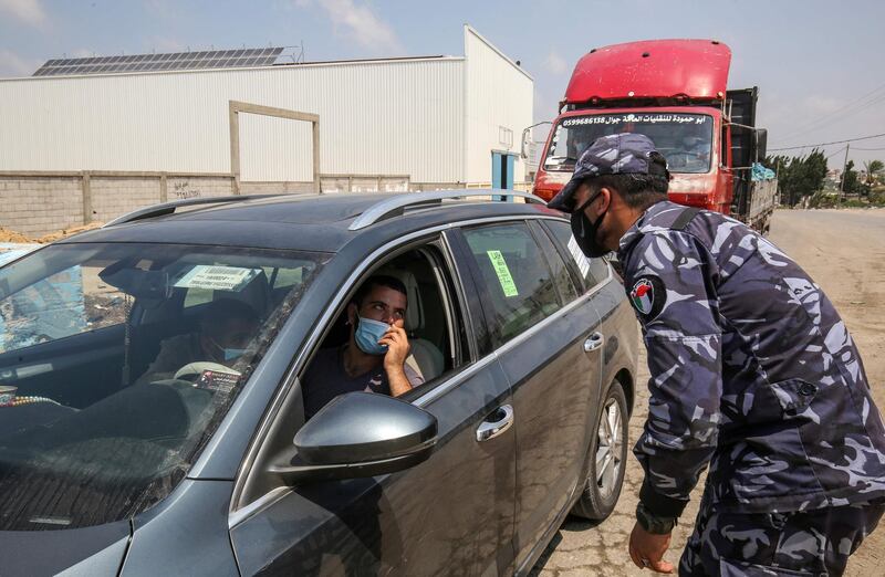 A Palestinian policeman speaks with a driver at a checkpoint in Rafah in the southern Gaza Strip on August 31, 2020, amid a lockdown due to increasing cases of COVID-19 infections. / AFP / SAID KHATIB
