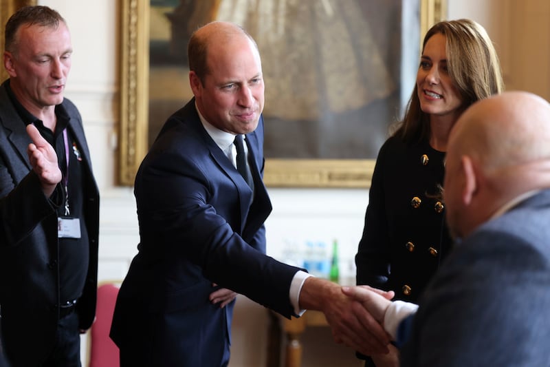 Prince William shakes hands with one of the volunteers. AP
