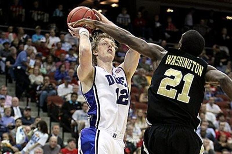 Kyle Singler of the Duke Blue Devils, in white, tries to shoot past Tavaris Washington, the Arkansas-Pine Bluff guard.