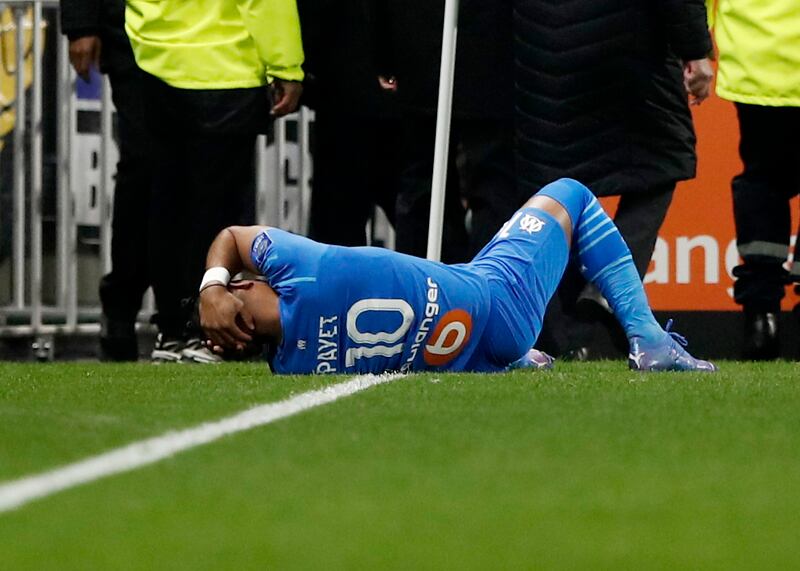 Marseille's Dimitri Payet is injured after being hit by a water bottle thrown by a Lyon supporter during the Ligue 1 match at Groupama Stadium, Lyon, France, on November 21, 2021. The match was later abandoned. AP