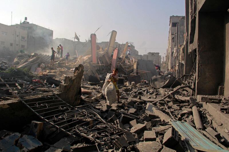 FILE - In this Aug. 2, 2014 file photo, Palestinians search through rubble of homes destroyed in Israeli strikes in Rafah, southern Gaza Strip.  The Israeli military said on Wednesday Aug. 15, 2018, its investigation focused on an Aug. 1, 2014, battle in the southern Gaza town of Rafah, one of the bloodiest incidents of the 2014 war in the Gaza Strip, has found no criminal wrongdoing by Israeli forces, although human rights advocates accused the military of a whitewash. (AP Photo/Hatem Ali, FILE)