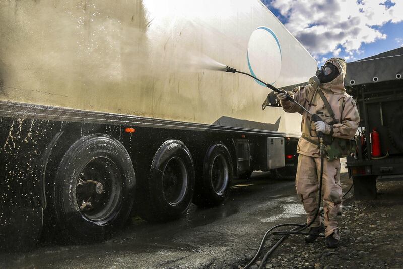 A Revolutionary Guard member disinfects a truck in the city of Sanandaj, western Iran, March 1. Tasnim News Agency via AP
