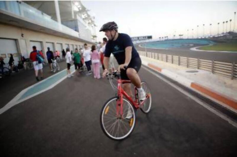 Rory Fidler bikes around the Yas F1 race track as part of his training for Tri Yas in Abu Dhabi. Sammy Dallal / The National