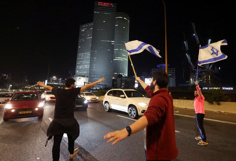 People hold Israeli flags as they block a road during a demonstration against Israel's nationalist coalition government's judicial overhaul. Reuters