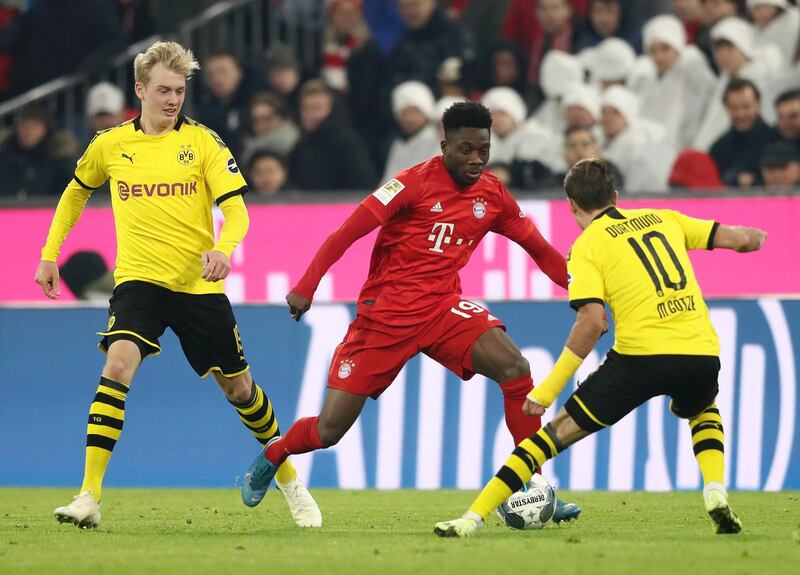 Bayern midfielder Alphonso Davies takes on Dortmund midfielder Mario Gotze. Getty Images