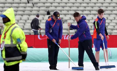 Stadium workers clear water from the covers as rain is expected to slightly delay the start of play during the Cricket World Cup match between New Zealand and Pakistan at the Edgbaston Stadium in Birmingham, England, Wednesday, June 26, 2019. (AP Photo/Rui Vieira)