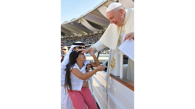 Pope Francis blesses the child before celebrating Mass at Zayed Sports City Stadium in Abu Dhabi. Vatican/Reuters