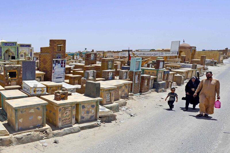 Shiite family visit the graves of their relatives at Wadi al-Salam cemetery during Eid Al Fitr in the Iraqi city of Najaf. AFP