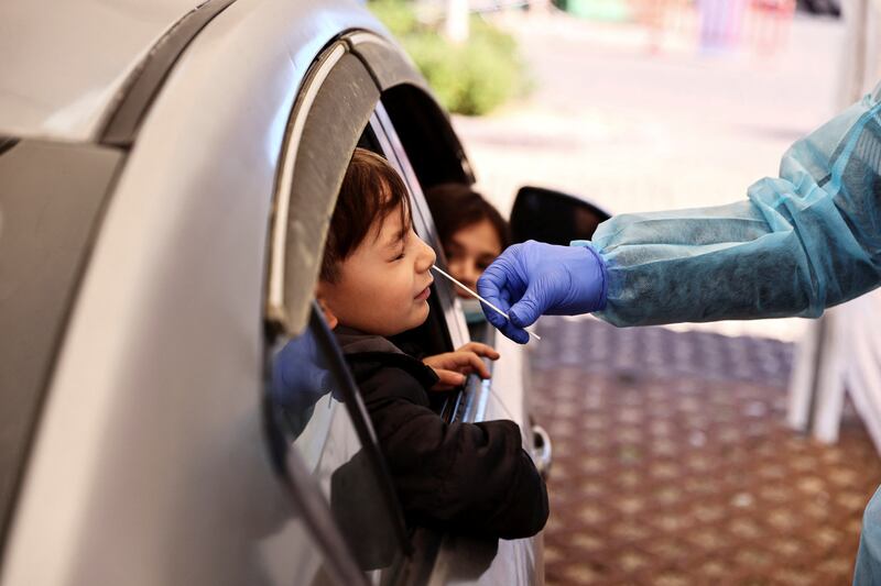 A boy is tested for Covid-19 at a drive-through site in Jerusalem on January 10, 2022 as Israel faced a surge in Omicron variant infections. Most Covid measures have been relaxed but vigilance is still required. Reuters