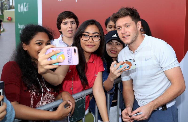 Niall Horan poses for selfies with fans during the pro-am at Emirates Golf Club. David Cannon / Getty Images