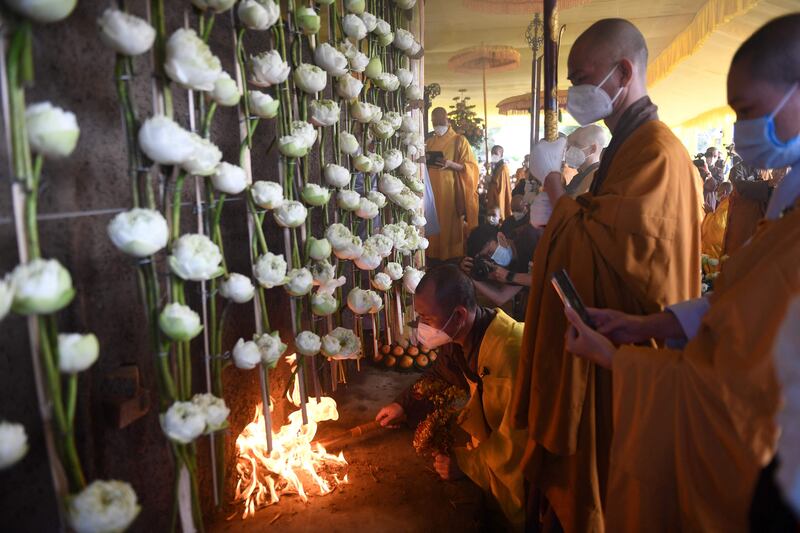 Buddhist monks stand by the cremator. AFP