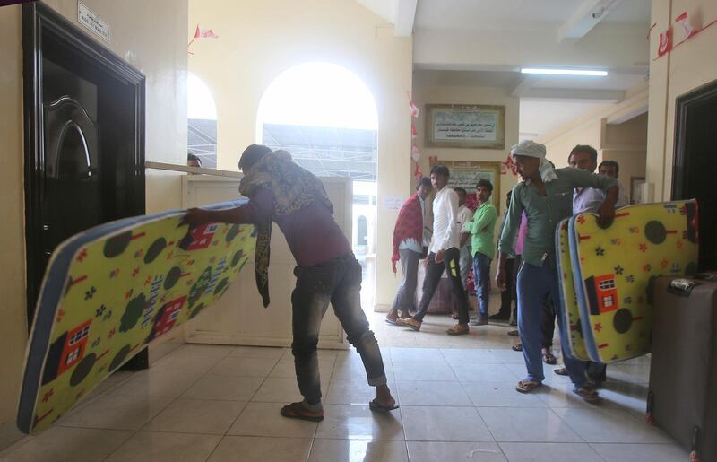 Workers prepare to stay in a school turned into a shelter. Kamran Jebreili / AP Photo