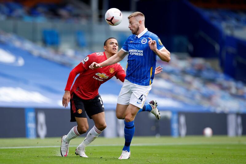 Adam Webster of Brighton and Hove Albion wins a header from Mason Greenwood of Manchester United. Getty