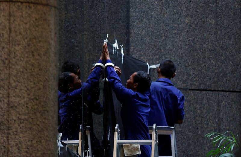 Workers cover a window to block the view inside a building at the Indonesia Stock Exchange. Darren Whiteside / Reuters