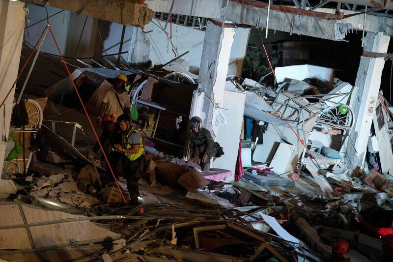 Rescue workers search for survivors in a collapsed Chuzon Super Market in Porac, Pampanga. AFP