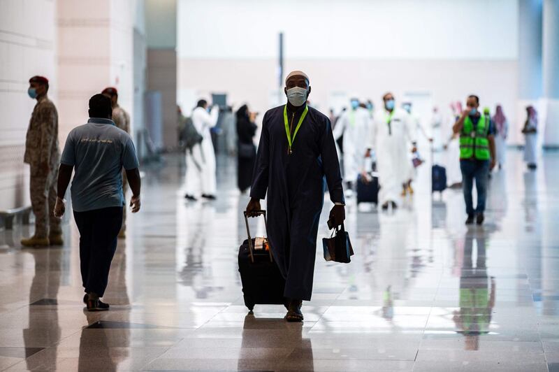 A handout picture provided by the Saudi Ministry of Hajj and Umra on July 25, 2020, shows a traveller, mask-clad due to the COVID-19 coronavirus pandemic, walking with his luggage as part of the first group of arrivals for the annual Hajj pilgrimage, at the Red Sea coastal city of Jeddah's King Abdulaziz International Airport. The 2020 hajj season, which has been scaled back dramatically to include only around 1,000 Muslim pilgrims as Saudi Arabia battles a coronavirus surge, is set to begin on July 29. Some 2.5 million people from all over the world usually participate in the ritual that takes place over several days, centred on the holy city of Mecca. This year's hajj will be held under strict hygiene protocols, with access limited to pilgrims under 65 years old and without any chronic illnesses. - === RESTRICTED TO EDITORIAL USE - MANDATORY CREDIT "AFP PHOTO / HO / MINISTRY OF HAJJ AND UMRA" - NO MARKETING NO ADVERTISING CAMPAIGNS - DISTRIBUTED AS A SERVICE TO CLIENTS ===
 / AFP / Saudi Ministry of Hajj and Umra / - / === RESTRICTED TO EDITORIAL USE - MANDATORY CREDIT "AFP PHOTO / HO / MINISTRY OF HAJJ AND UMRA" - NO MARKETING NO ADVERTISING CAMPAIGNS - DISTRIBUTED AS A SERVICE TO CLIENTS ===
