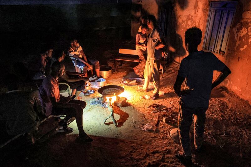 People cook on a campfire at a school that has been turned into a shelter for displaced Sudanese in the northern border town of Wadi Halfa, near Egypt, on September 11. AFP