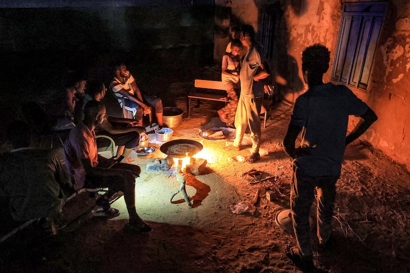People cook on a campfire at a school that has been turned into a shelter for displaced Sudanese in the northern border town of Wadi Halfa, near Egypt, on September 11. AFP