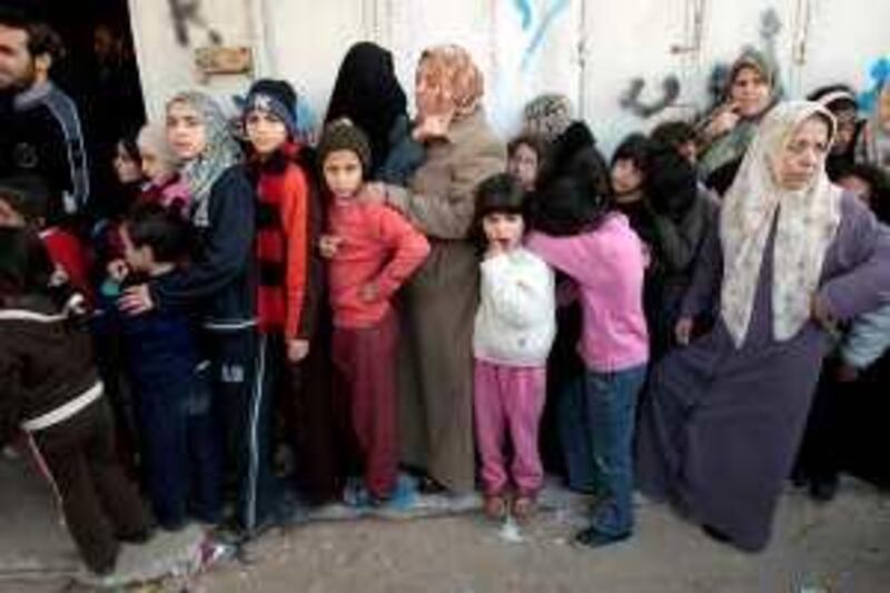 Palestinians wait in line to buy bread at a bakery in Gaza January 5, 2009. Combat between Israeli troops and Hamas militants raged on Monday as Israel pressed home its ground assault in Gaza in the face of French-led diplomatic efforts to broker a ceasefire. REUTERS/Mohammed Salem (GAZA) *** Local Caption ***  JER213_PALESTINIANS_0105_11.JPG