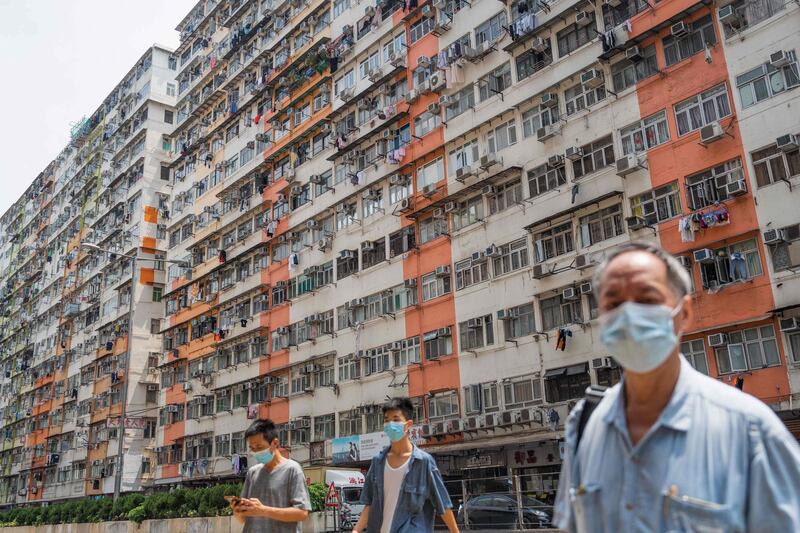 Pedestrians cross a road past apartment blocks in Hong Kong’s To Kwa Wan area. AFP