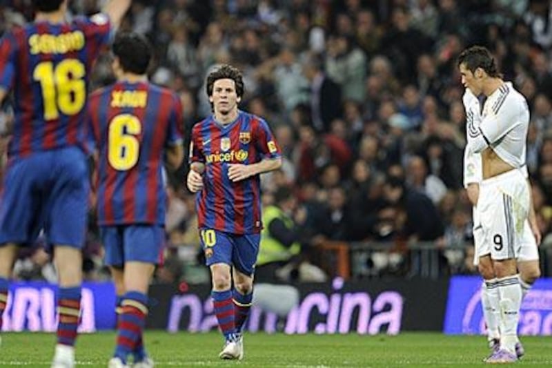 Lionel Messi, centre, celebrates after opening the scoring against Real Madrid as Cristiano Ronaldo, right, looks on.