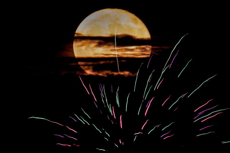 The Super Moon rises behind fireworks in Kansas City, Missouri. AP