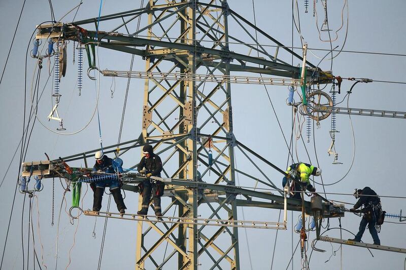 Workers prepare an electricity transmission tower, also called an electricity pylon, in order to hang electricity transmission cables from it on December 4, 2014 near Luebben, Germany. Germany is expanding its electricity grid as part of its large-scale shift from conventional coal, gas and nuclear-based energy production to renewable sources, especially wind and solar. Sean Gallup / Getty Images