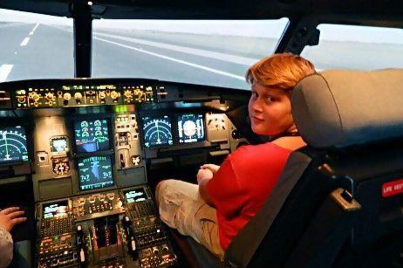 Joe Thompson, 11, at the controls of an Etihad Airways Airbus A320 flight simulator. The Al Ain schoolboy is stranded in the UAE after developing a chronic fear of flying. He was due to return to the UK over the summer.