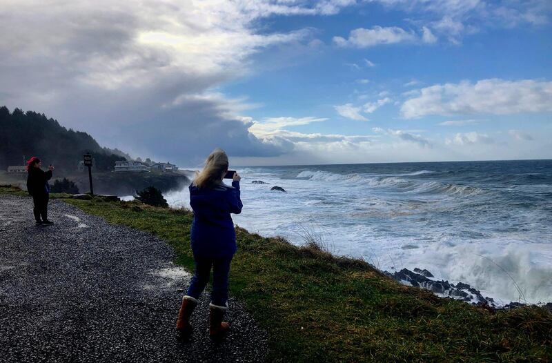 Onlookers use smartphones to film waves crashing ashore at Rodea Point in Lincoln County, Oregon during an extreme high tide that coincided with a big winter storm. AP Photo/Gillian Flaccus