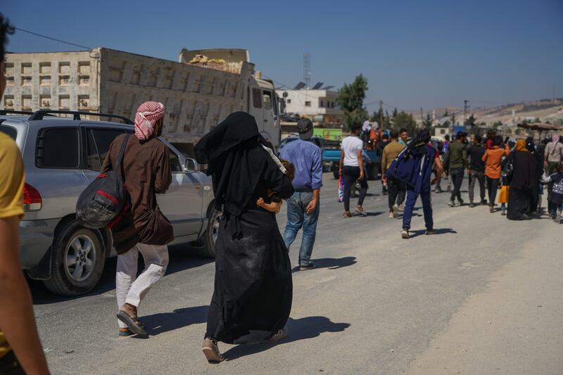 A man and his wife run towards the Syrian-Turkish border in a peace convoy called Al Salam, the organisers of which aim to enable Syrians to leave Idlib and the civil war behind for pastures new in Europe. 