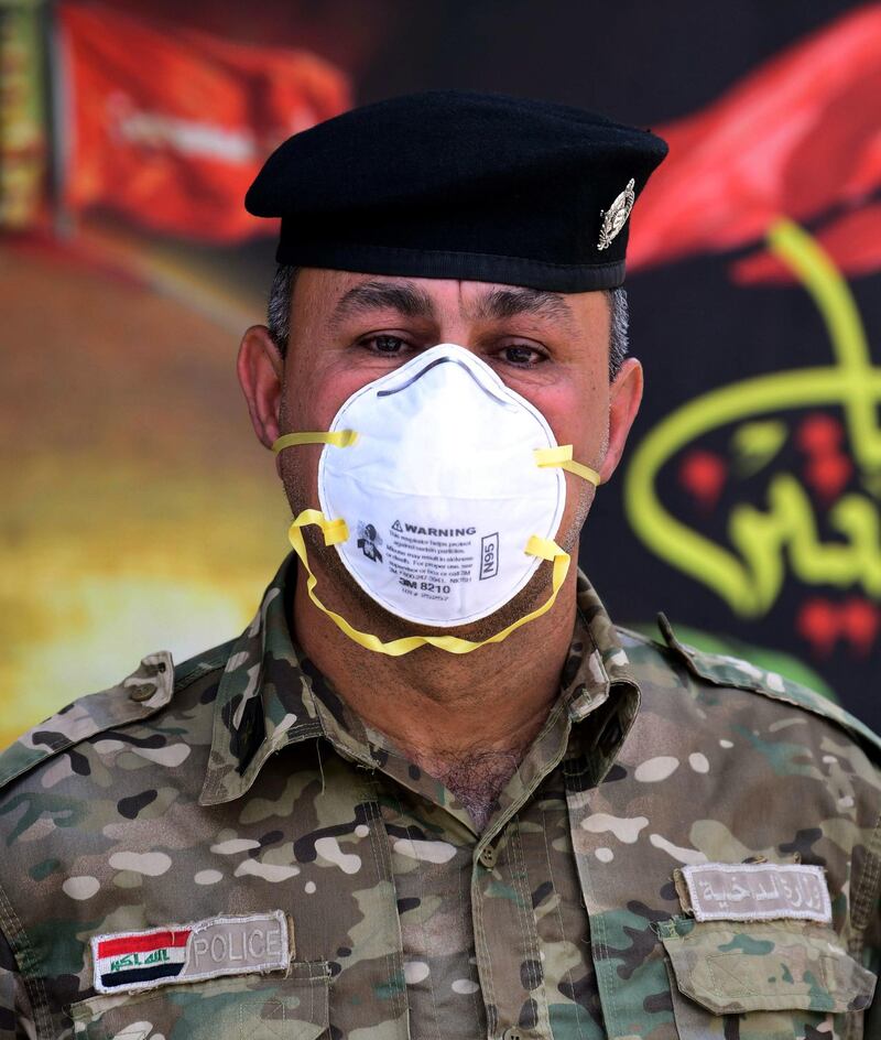 Iraqi police officer Muthana Abdul Rahim poses for a portrait while wearing a face mask in Baghdad, Iraq.  EPA