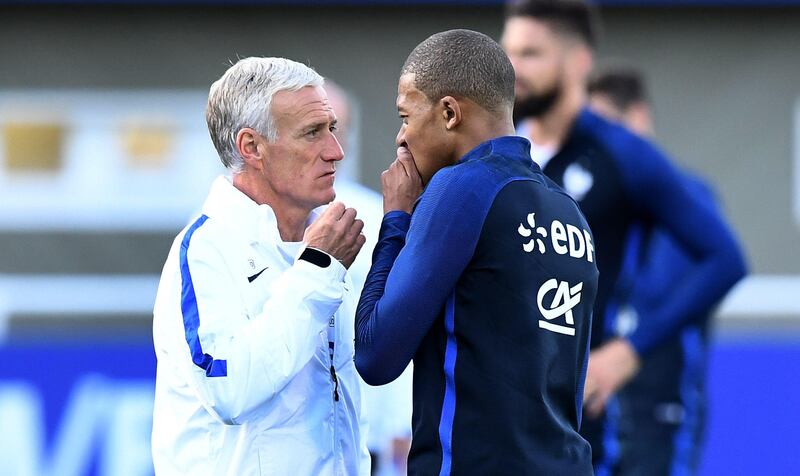 France's head coach Didier Deschamps (L) speaks with France's forward Kylian Mbappe during a training session in Clairefontaine-en-Yvelines on October 3, 2017, in preparation for the team's World Cup 2018 qualifying football match against Bulgaria.  / AFP PHOTO / FRANCK FIFE