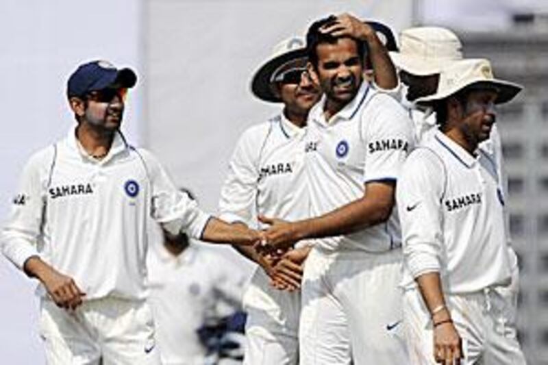 Indian cricketers congratulate Zaheer Khan, second from night, after his first seven-wicket haul in an innings.