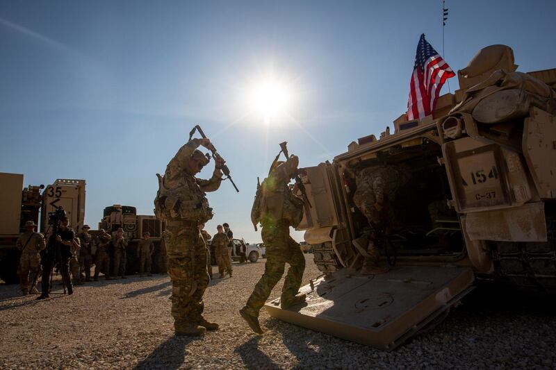 Crewmen enter Bradley fighting vehicles at a US military base at an undisclosed location in Northeastern Syria, Monday, Nov. 11, 2019. The deployment of the mechanized force comes after US troops withdrew from northeastern Syria, making way for a Turkish offensive that began last month. (AP Photo/Darko Bandic)