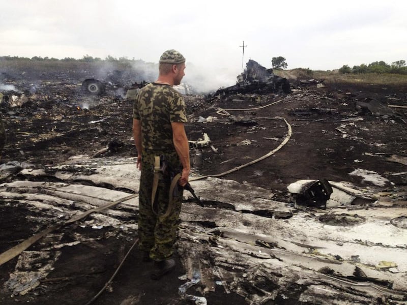 An armed pro-Russian separatist stands at a site of a Malaysia Airlines Boeing 777 plane crash in the settlement of Grabovo in the Donetsk region, July 17, 2014. The Malaysian airliner MH17 crashed over eastern Ukraine on Thursday, killing all 295 people aboard, a Ukrainian interior ministry official said. Maxim Zmeyev/Rueters