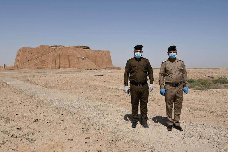 Iraqi security forces wearing face masks pose near the Great Ziggurat temple, a massive Sumerian construction dedicated to the moon god Nanna which dates back to 2100BC in the ancient city of Ur that falls now in southern Iraq's Dhi Qar province. AFP