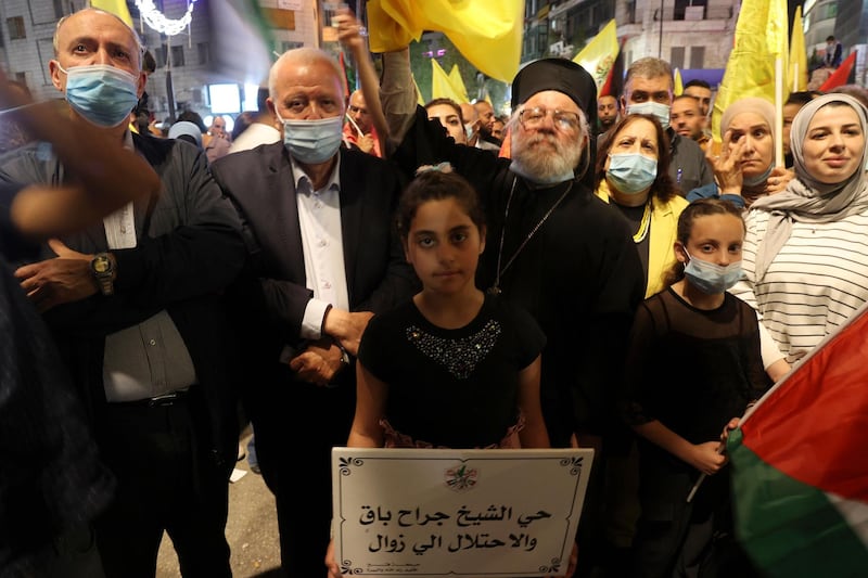 Fatah supporters and Archimandrite Abdullah Yulio, centre left, demonstrate in the West Bank city of Ramallah in solidarity with Palestinian families facing Israeli eviction orders in the Sheikh Jarrah neighbourhood of East Jerusalem. AFP